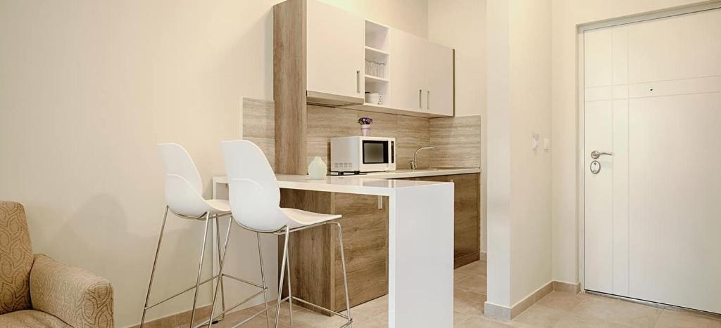 a kitchen with white chairs and a counter top at Appartamenti Amalfi Centro Storico in Amalfi