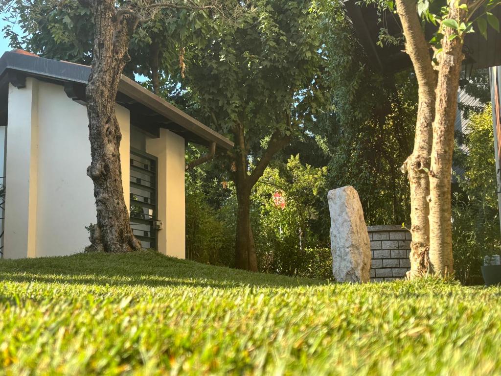 ein Stein im Gras neben einem Haus in der Unterkunft Brixia Garda Homes in Rezzato