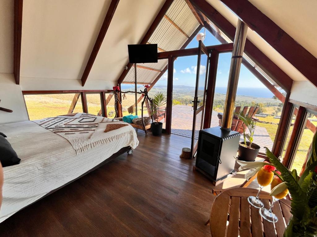 a bedroom with a bed and large windows at Terevaka Lodge Rapa Nui in Hanga Roa