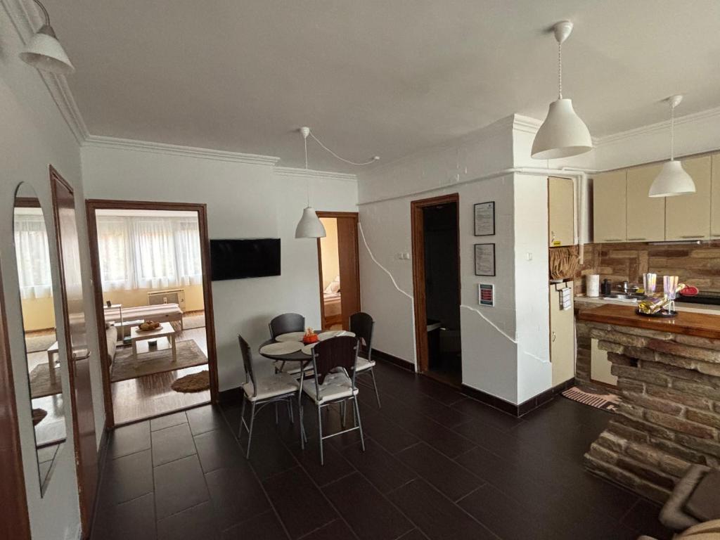 een keuken en een woonkamer met een tafel en stoelen bij Zenora Apartman in Makó