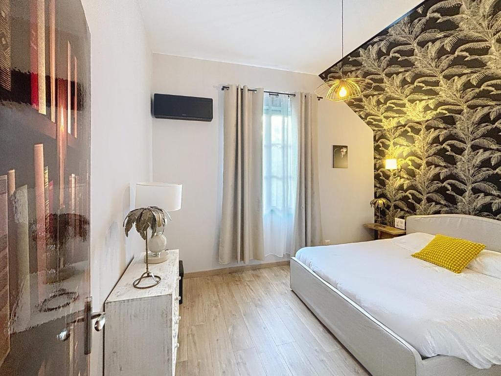 een slaapkamer met een bed en een muurschildering bij T2 rénové au coeur de Vendôme avec parking - Le Kozy in Vendôme