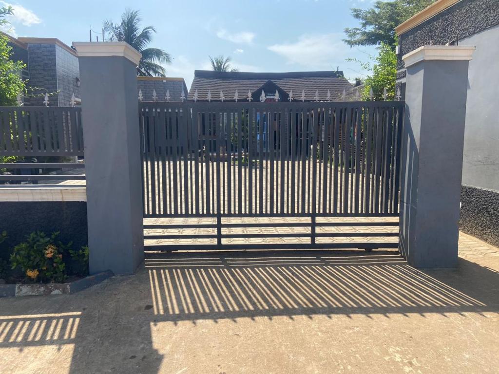 una puerta a una casa con una valla en Tracer Wave Cabin, en Akwanga