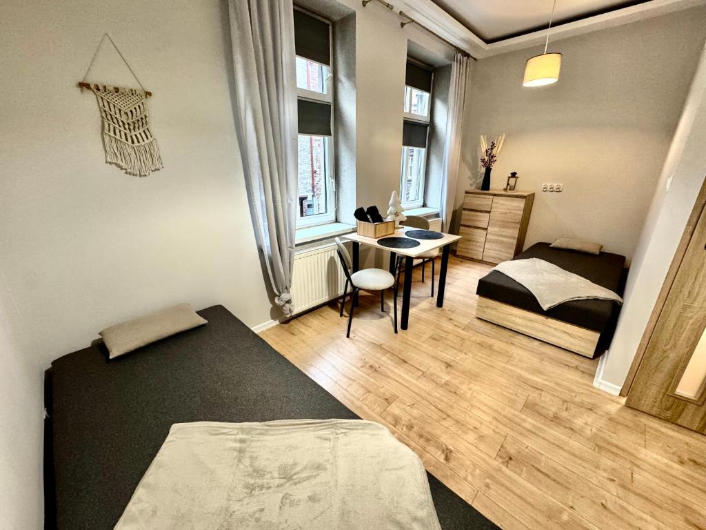 ein Schlafzimmer mit einem Bett, einem Tisch und einem Schreibtisch in der Unterkunft Pokój przy Parku Róż II in Chorzów