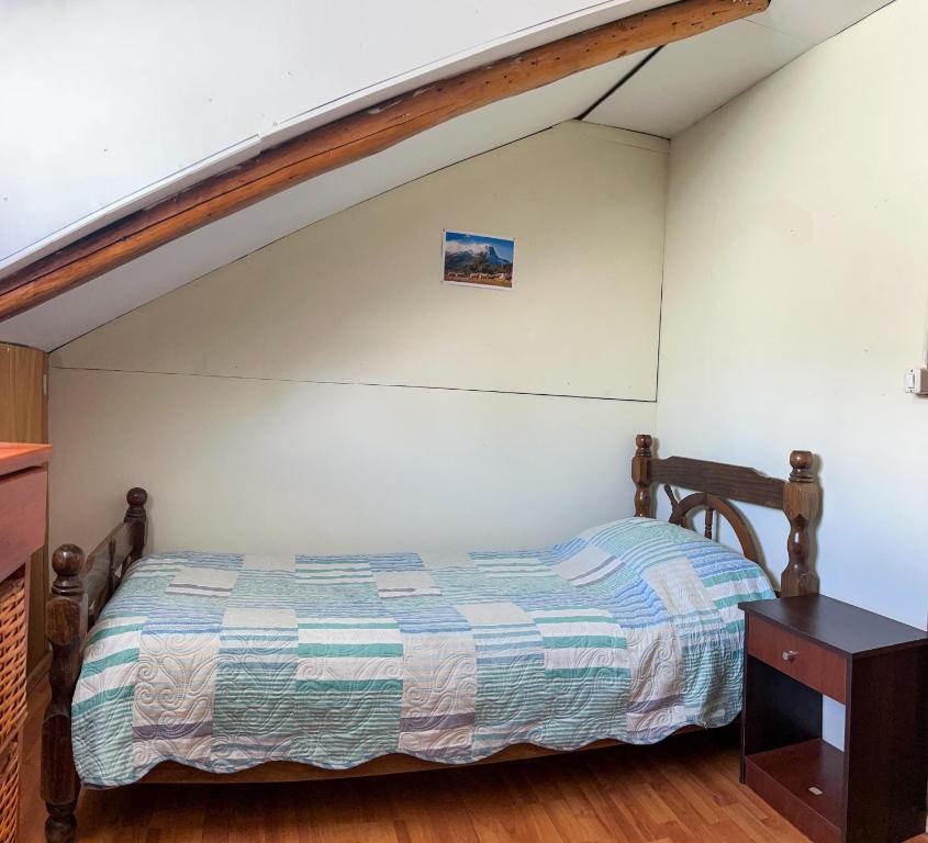 a bedroom with a bed and a wooden table at La cascada in Futaleufú