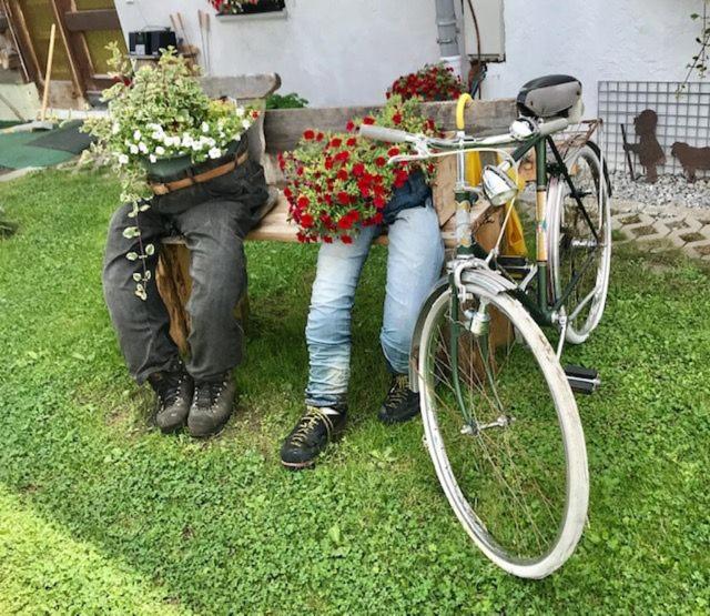 Un hombre y una mujer sentados en un banco con flores. en Modern Gemütlich, en Pflach