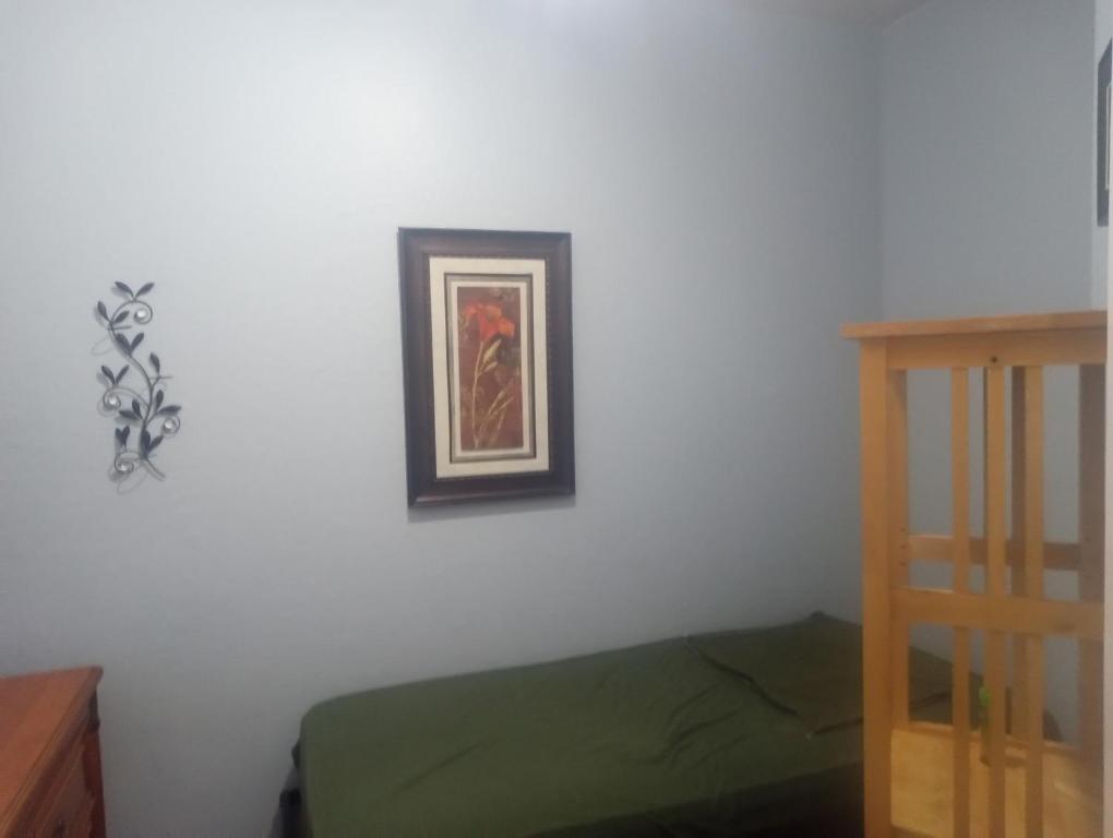 a bedroom with a white wall with a picture on the wall at Westgate Tiny Room 94th in Phoenix