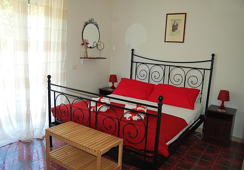 a bedroom with a bed with red pillows at Villa Nini' Exclusive Nature by ElodeaGroup in Pellezzano