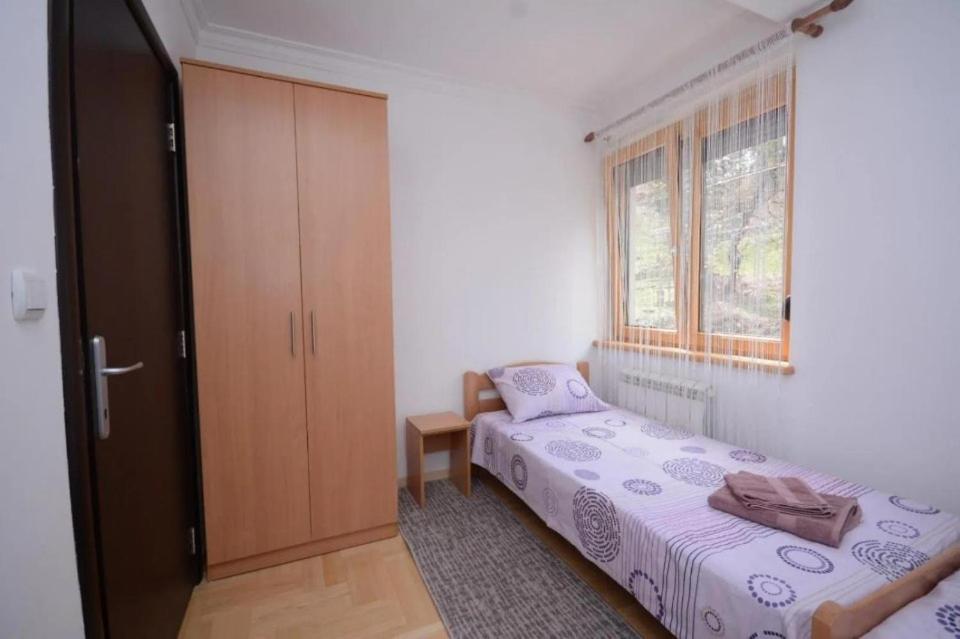 - une chambre avec deux lits, une armoire et une fenêtre dans l'établissement Center 4U, à Vrnjačka Banja