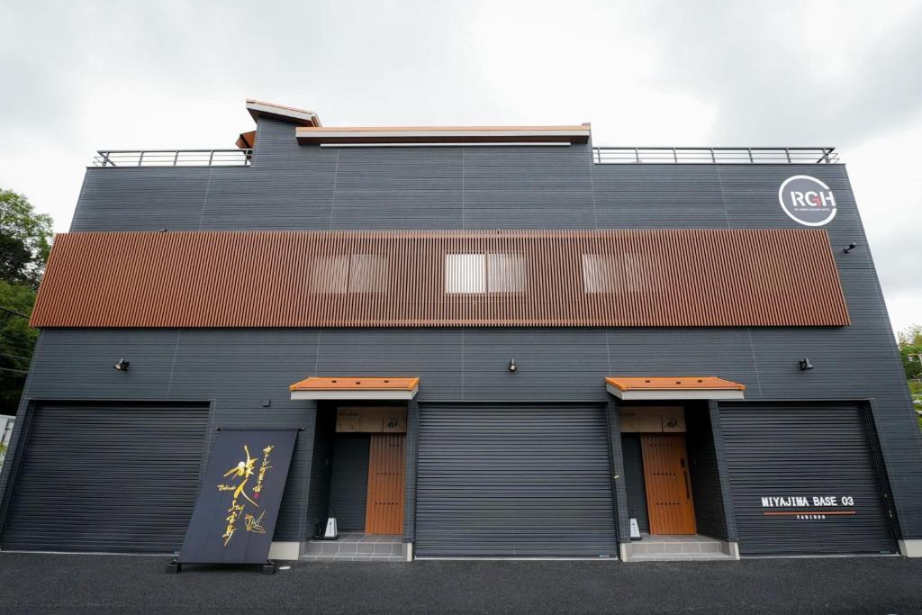 a black building with four garage doors in front at Tabiudo Stay Miyajima 01-02 - Vacation STAY 20514 in Fukae