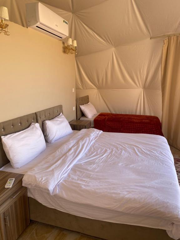 a bed in a room with a tent at Lunara rum camp in Wadi Rum