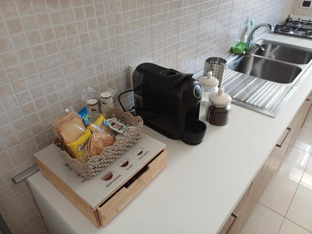 een aanrecht met een mand met eten en een wastafel bij Elettra House Anzio in Anzio