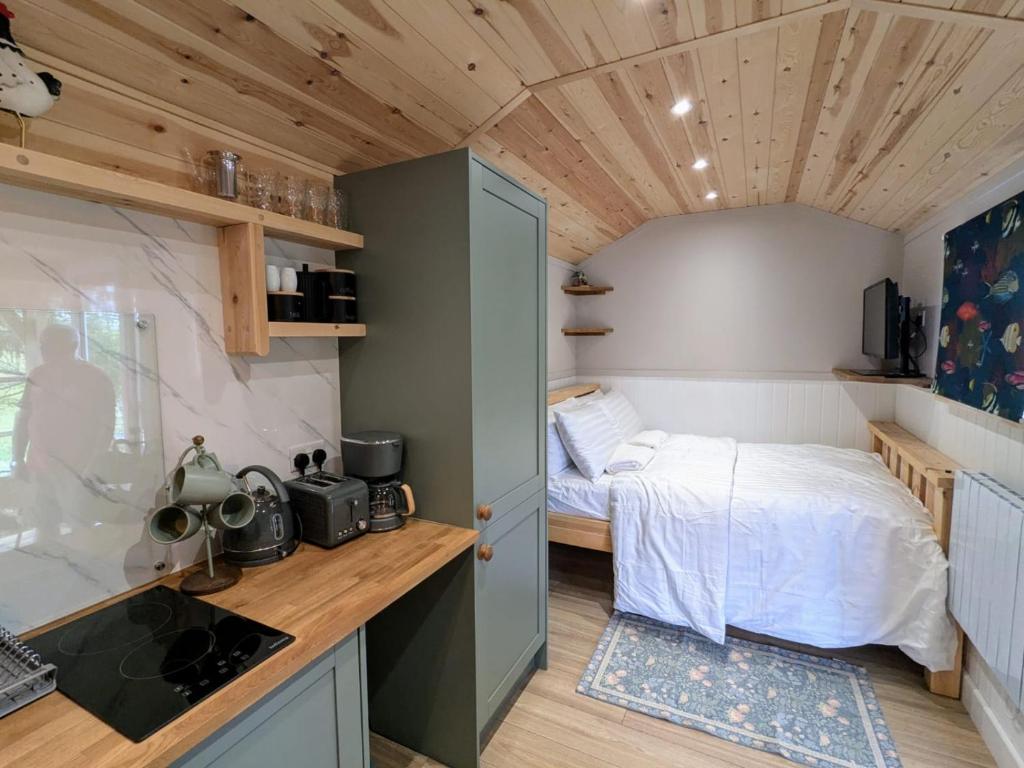 ein kleines Schlafzimmer mit einem Bett und einer Küche in der Unterkunft The Rodney Shepards hut in Eyam