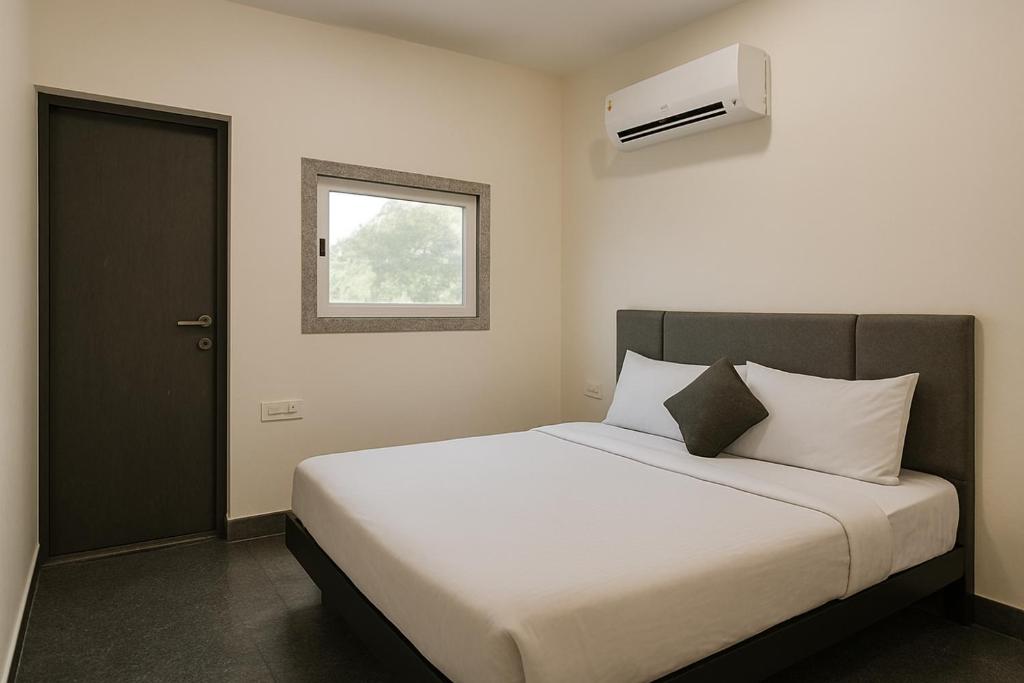 une chambre avec un lit blanc avec une fenêtre dans l'établissement Shri Radhey Krishna Paying Guest House, à Mathura