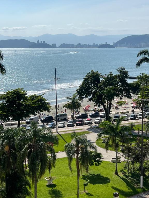 a view of a beach with palm trees and a parking lot at Apê pé na areia in Santos