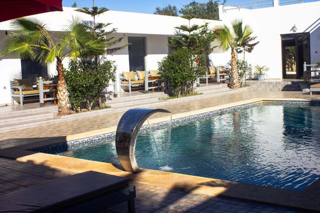 a swimming pool in a hotel with palm trees at Dar naima in Al Ghar