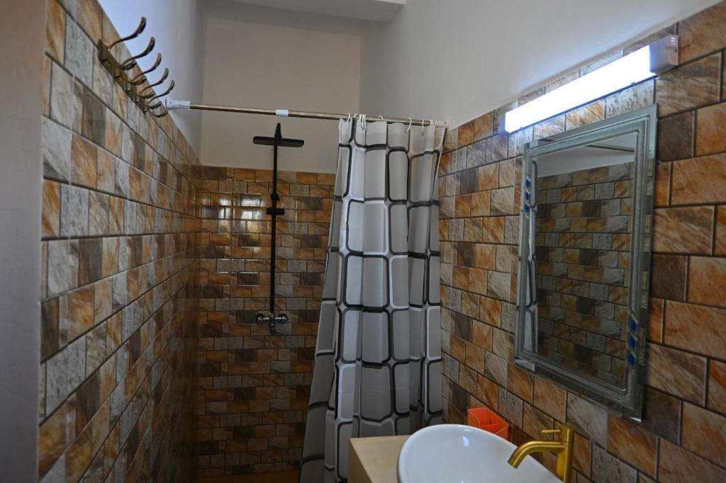 Firas Village في واتامو: حمام مع ستارة دش ومغسلة