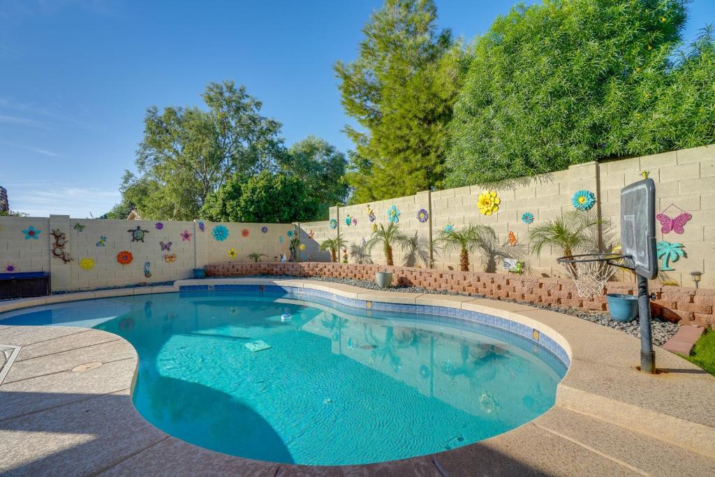 a swimming pool in front of a brick wall at Pool, Patio and Hot Tub Surprise Home Near Golfing! in Surprise