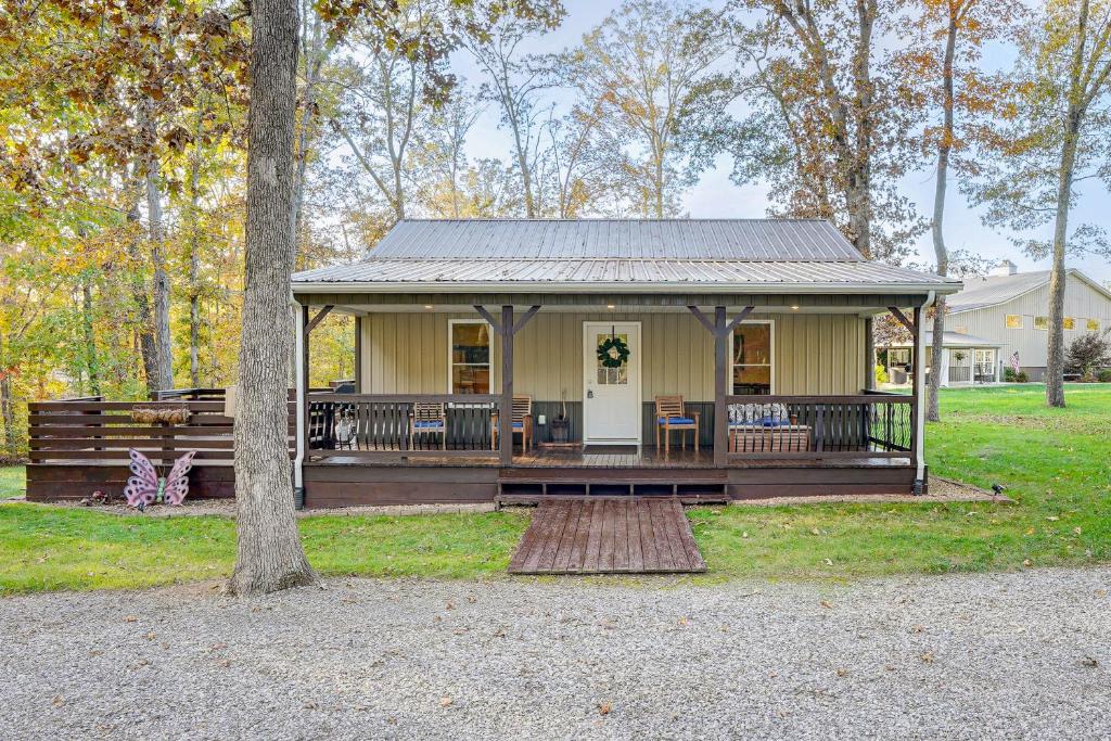 a small yellow house with a porch and a tree at Walk to Marina and Beach Charming Home in Hardin in Aurora