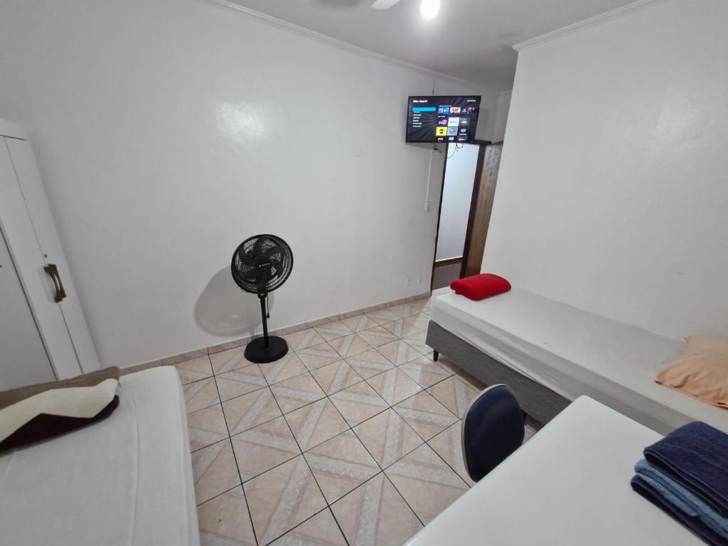 een kamer met een bed en een ventilator. bij Hotel Pousada Liberdade in Pindamonhangaba