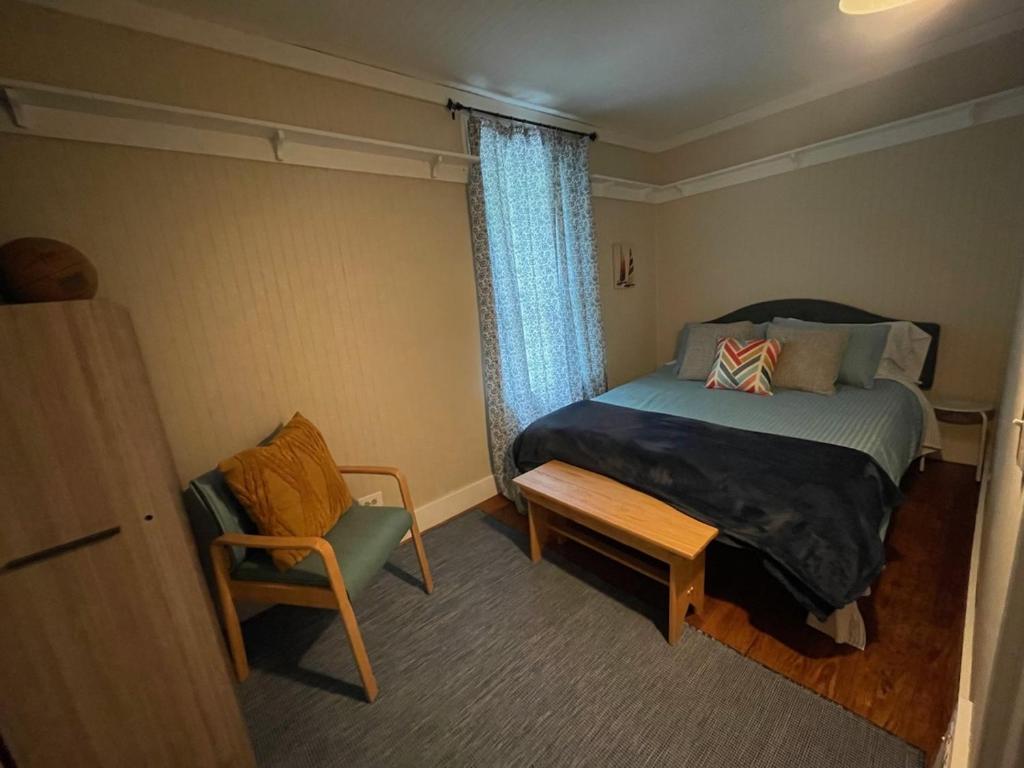 une petite chambre avec un lit et une chaise dans l'établissement Eastside Abode - Local Living Weekly & Monthly Rentals Only Contact for Monthly Rates, à Grand Haven