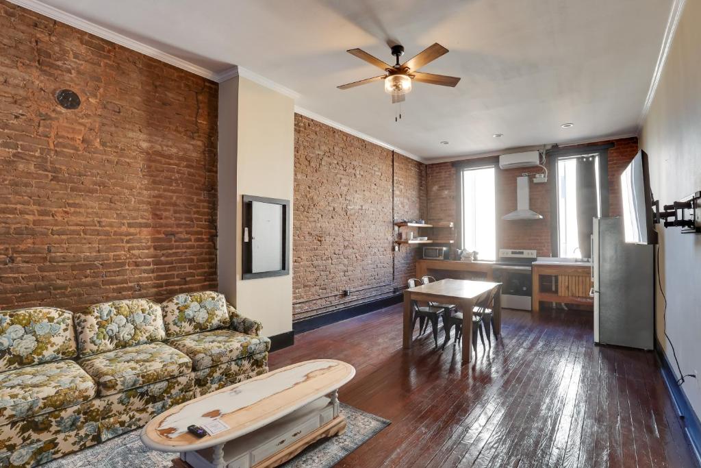 a living room with a couch and a brick wall at Convenient Couples Retreat in Dtwn Marshall! in Marshall