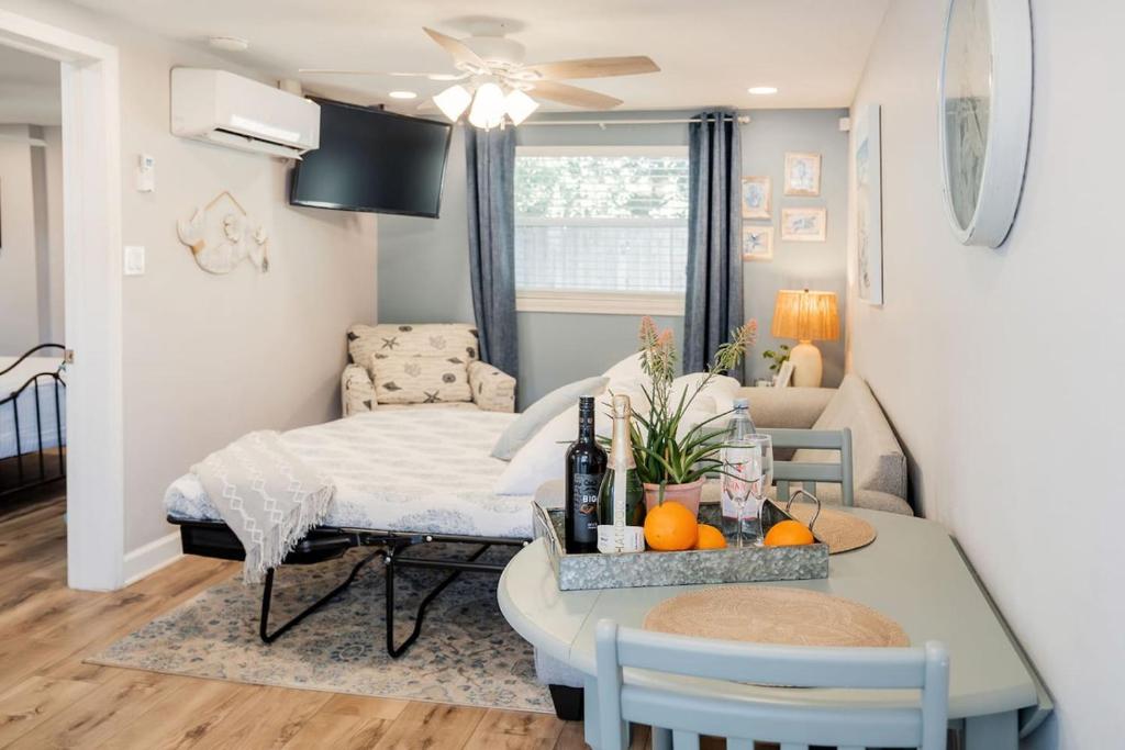 ein Wohnzimmer mit einem Bett und einem Tisch mit Orangen in der Unterkunft Cozy Coastal Cottages of Dunedin 3 in Dunedin