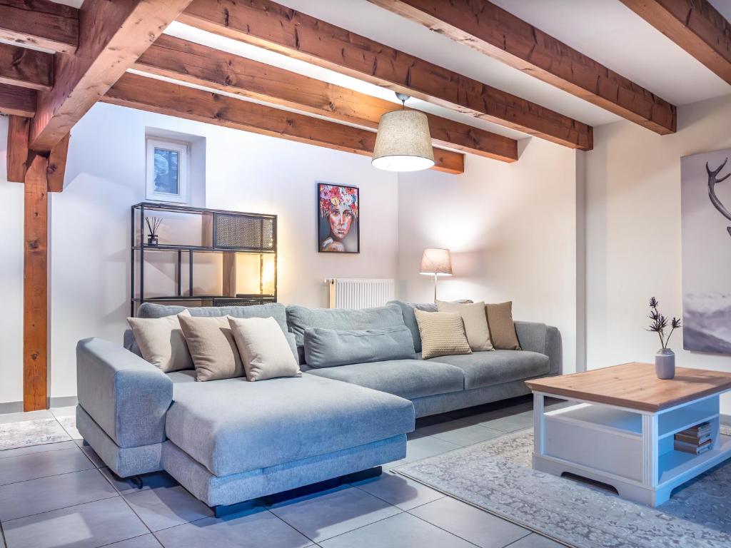 a living room with a blue couch and a table at Résidence de 80 m2 avec balcon & cour alsacienne - début Route des Vins in Marlenheim