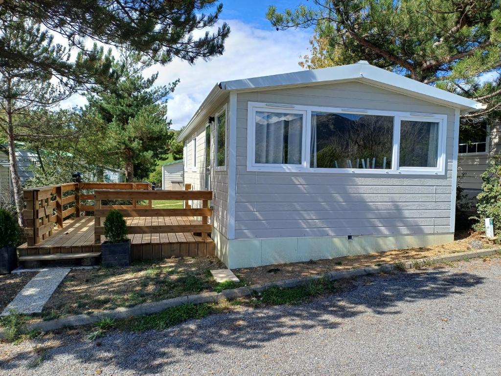 a tiny house with a porch and a window at Le panoramique in Saillagouse