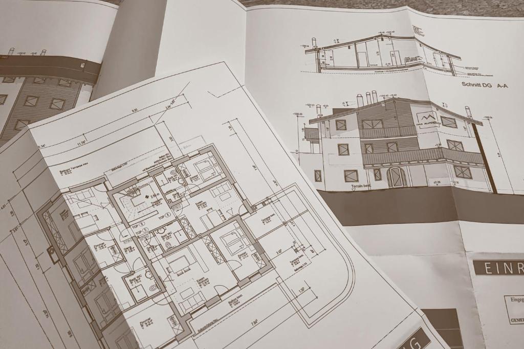 een open boek met een tekening van een gebouw bij das Alpenblick & Outdoor Lodge Nauders in Nauders