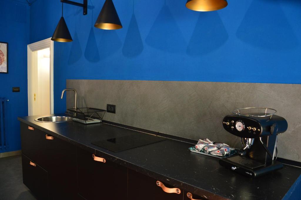 una cucina con bancone nero e parete blu di B&B Maison Lunarè ad Altamura