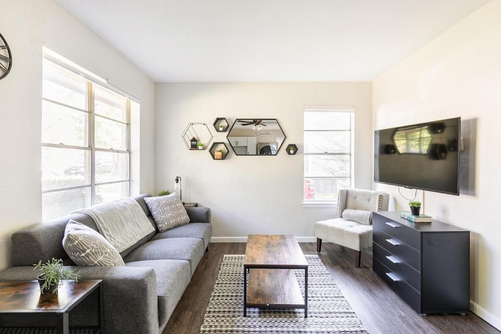 a living room with a couch and a tv at Find Peace at Charming Comfortable Downtown Home in Whitesboro