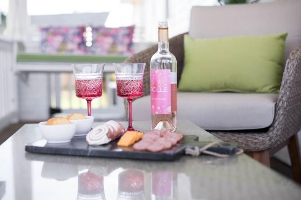 een dienblad met twee wijnglazen en een fles op een tafel bij Pink Door Cottage in Greer