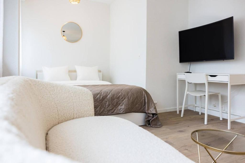 The Mini Minimalist Free Parking في Pully: غرفة معيشة مع أريكة وتلفزيون