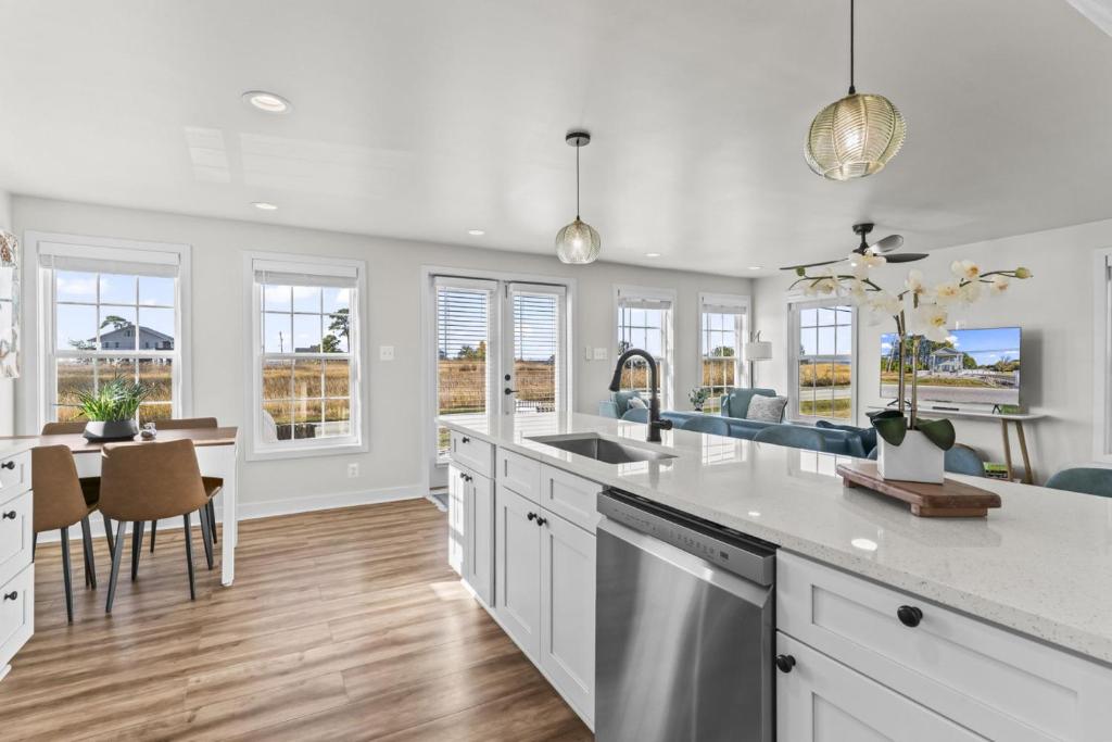 een keuken met witte kasten en een tafel en stoelen bij St Georges Getaway w firepit in Abbeyville