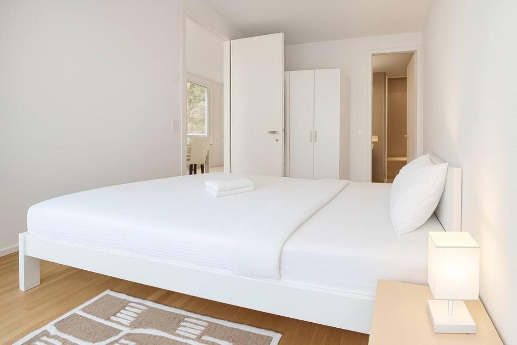 Montchoisi 1 bedroom Near Gare Ouchy Smart Lock في Ouchy: غرفة نوم بيضاء مع سرير أبيض كبير