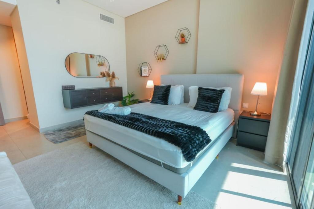 een slaapkamer met een groot bed en een spiegel bij Park View Saadiyat Chic 1 BD in Mushayrib