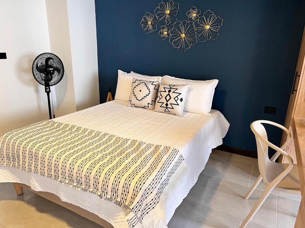 a bedroom with a bed with a blue wall at HAB 108- Hermosa, cómoda y moderna in Medellín