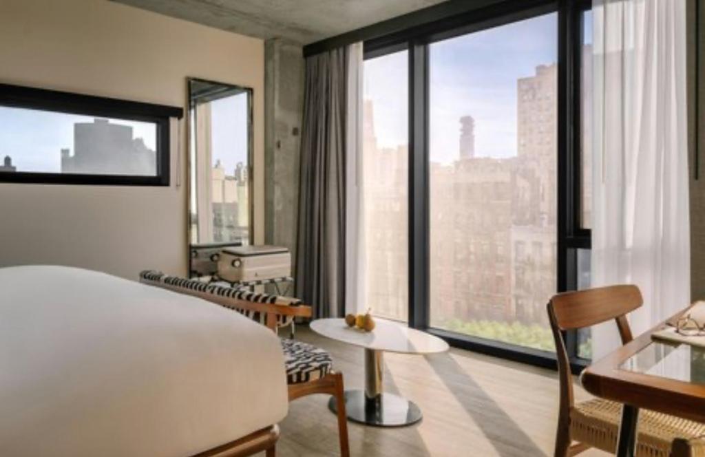 a hotel room with a bed and a large window at Merchant LES in New York