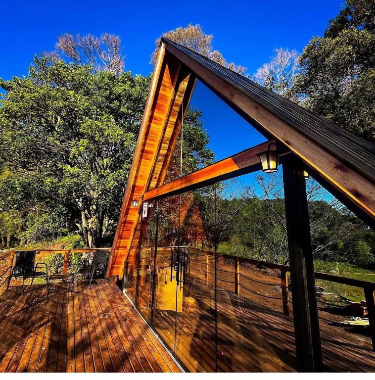 a screened in deck with a wooden roof at chale aster camping santa barbara in Francisco Beltrão