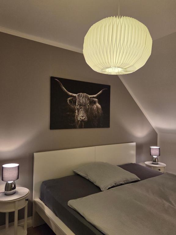 a bedroom with a bed with a picture of a bull at Muttis Haus -Auf dem Felde in Ummern