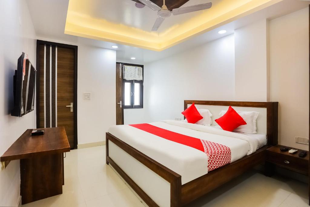 une chambre avec un grand lit avec des oreillers rouges dans l'établissement Super Hotel O Kazhakkoottam Near Technopark Phase 3, à Trivandrum