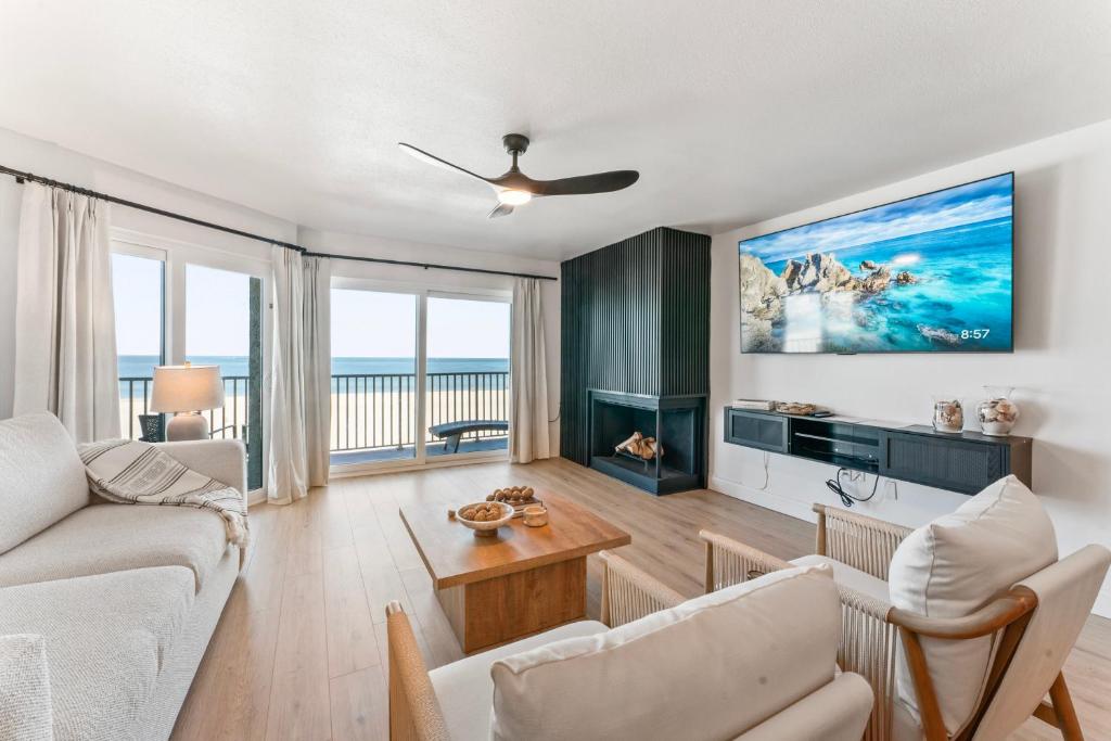 a living room with a couch and a table at Newly Reno Beachfront Escape I Steps to Beach in Clearwater Beach