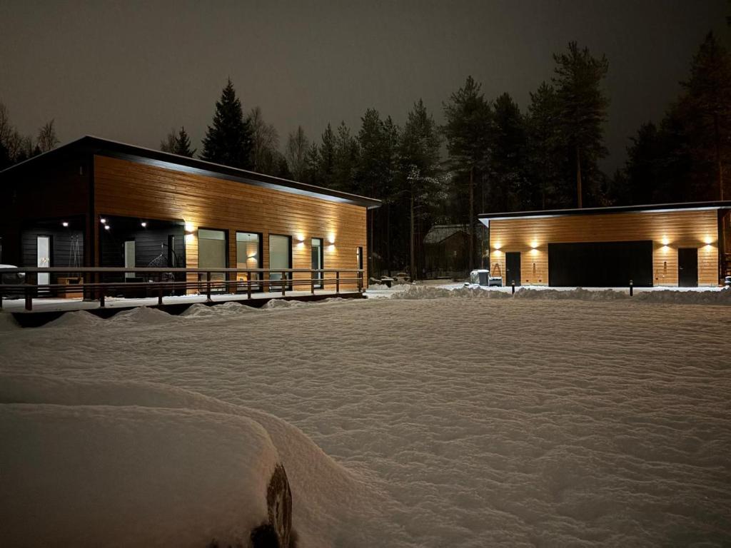 een gebouw in de sneeuw 's nachts met lichten bij Villa Snowy Owl in Rovaniemi