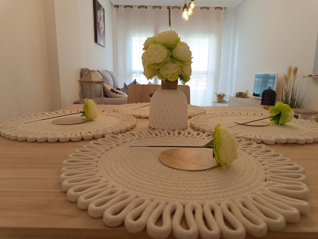 a table with a vase of flowers on top of it at Dúplex JUNI in Bádames
