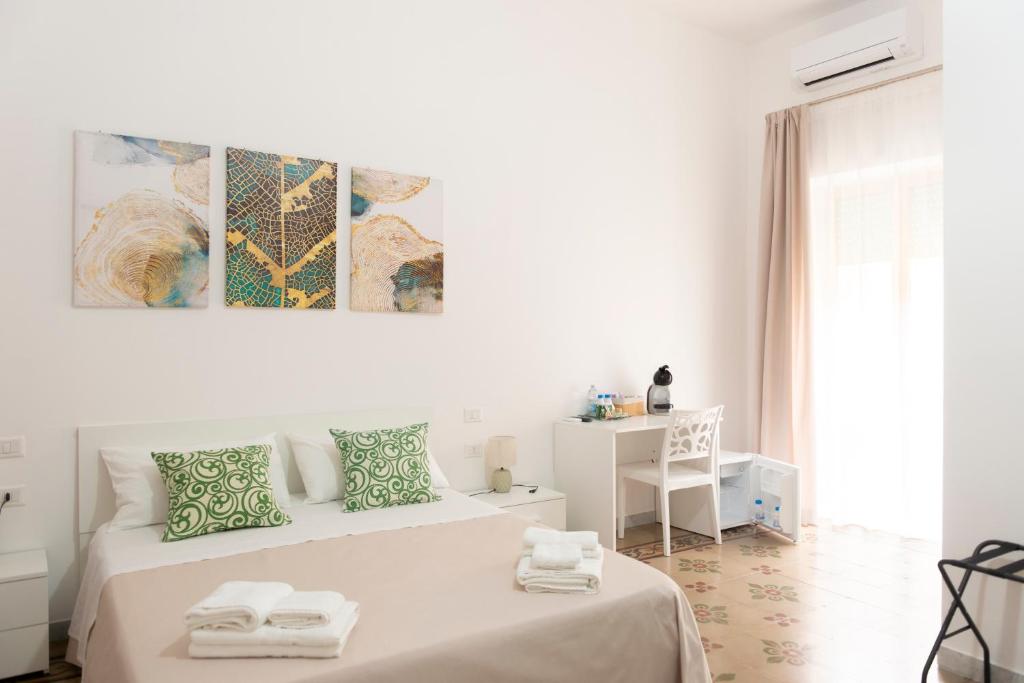a white bedroom with a bed with towels on it at B&B Gaudio in San Marco Argentano