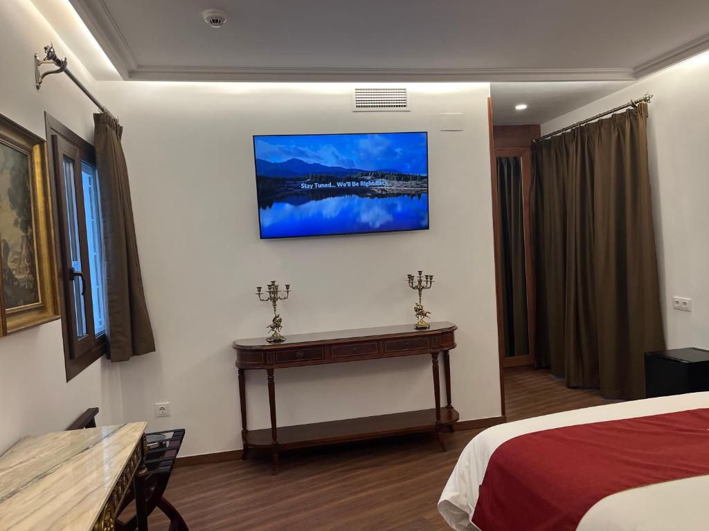 a hotel room with a bed and a table at Hotel Boutique Casón De Los López in Toledo