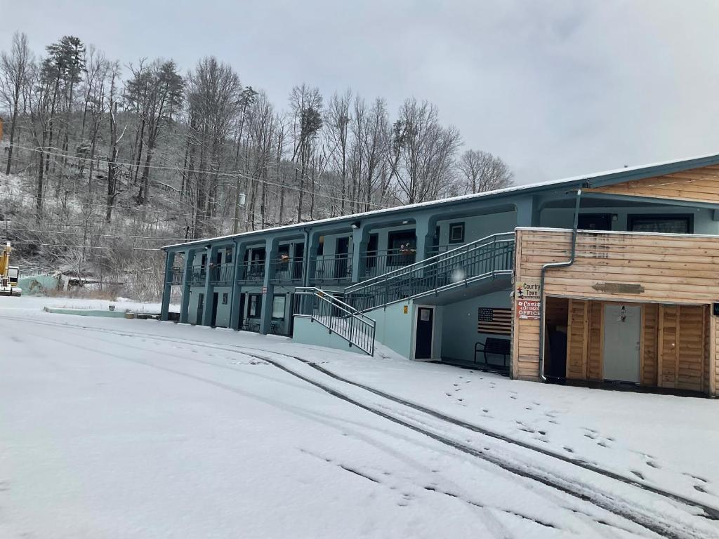 a building with snow on the ground in front of it at Country Town N' Suites in Gatlinburg
