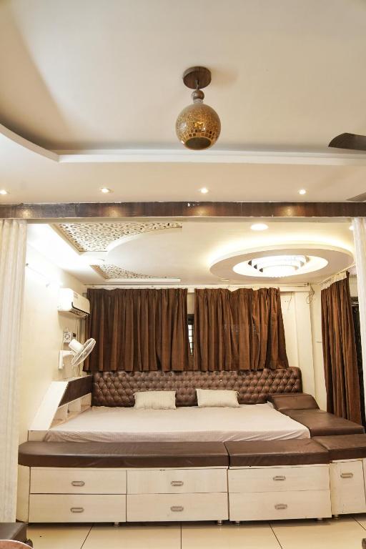 a bedroom with a large bed in front of a curtain at Nest & Fest in Indore