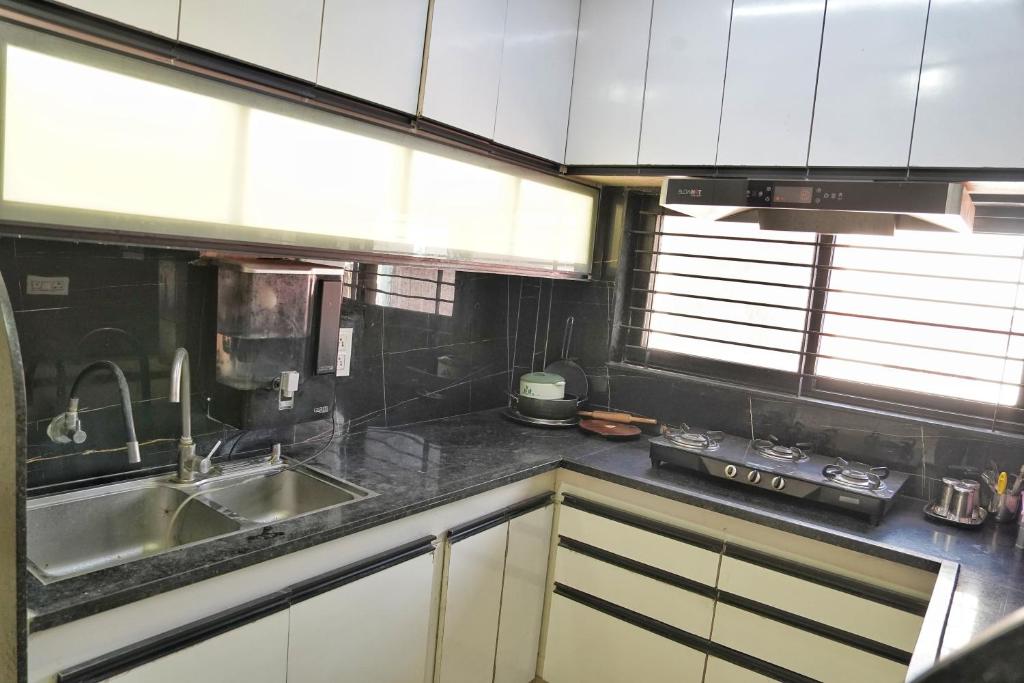 a kitchen with a sink and a counter top at Nest & Fest in Indore