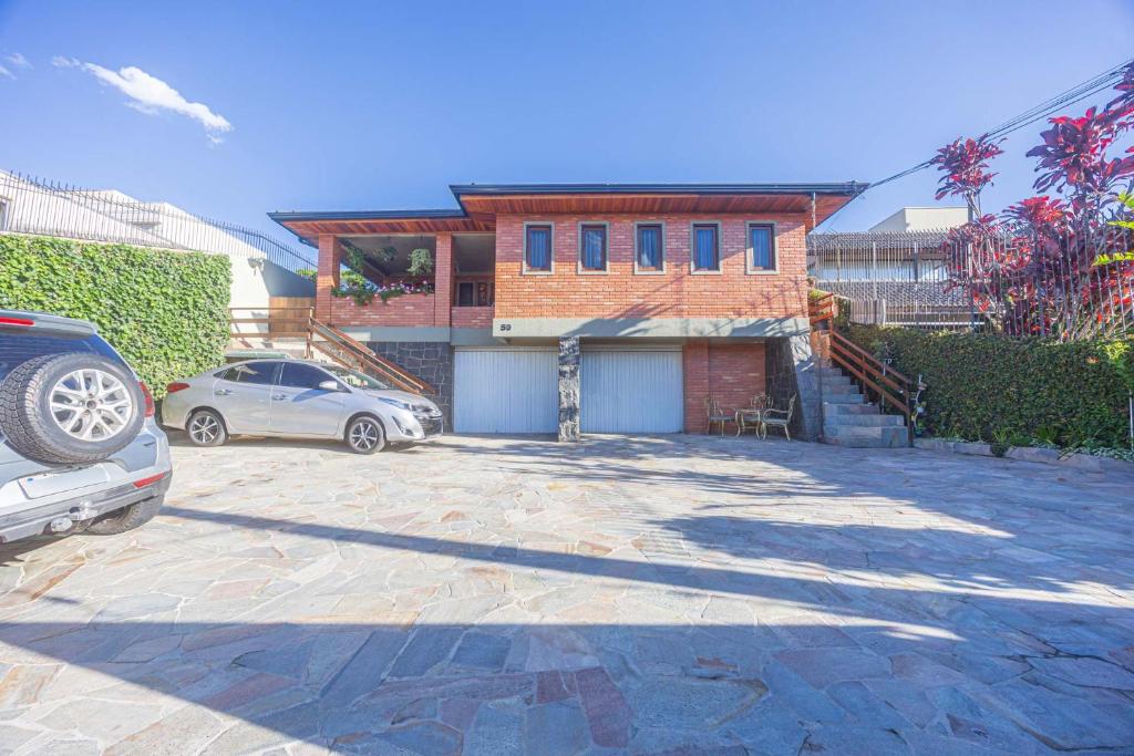 a house with a car parked in a driveway at STUDIO KITSOSSEGO in Curitiba